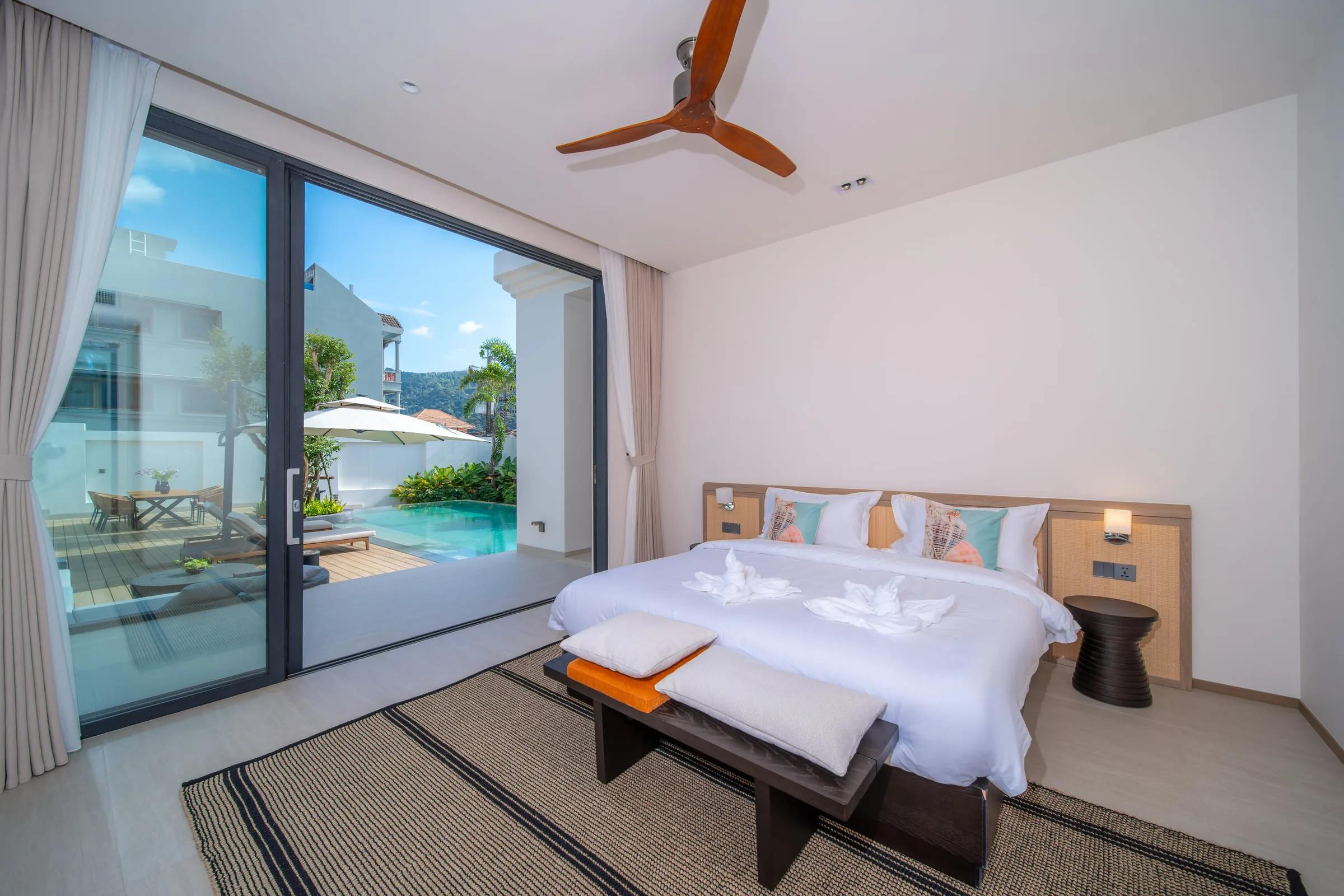 Bedroom with a double bed and sliding doors opening directly onto the pool deck