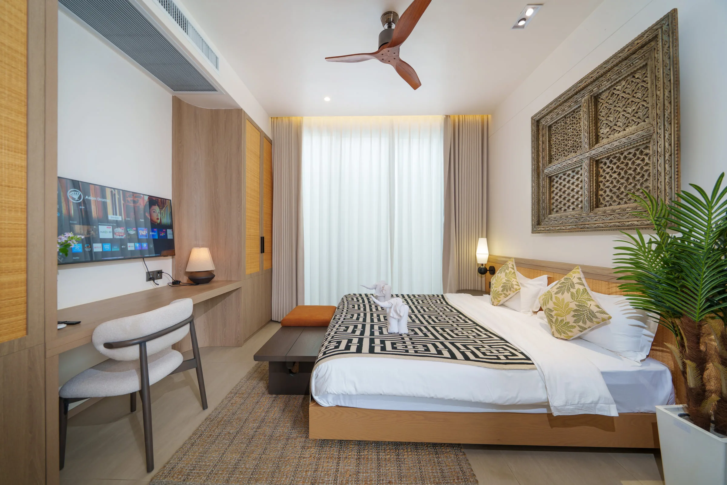 Bedroom with a double bed, desk, wall-mounted television and built-in wardrobe
