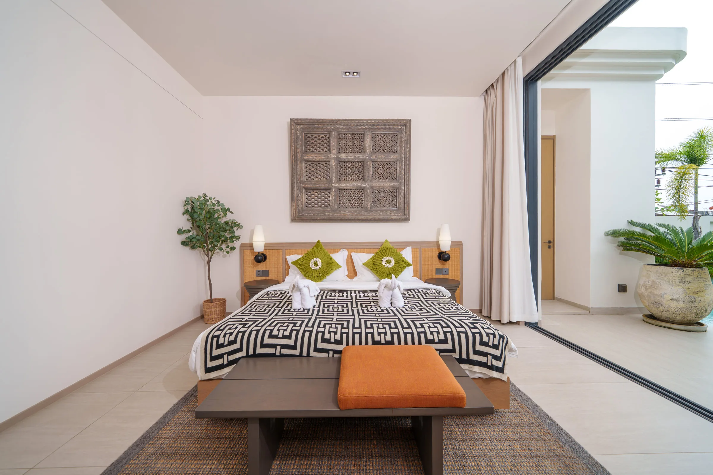 Bedroom with a double bed and sliding doors onto a planted side courtyard