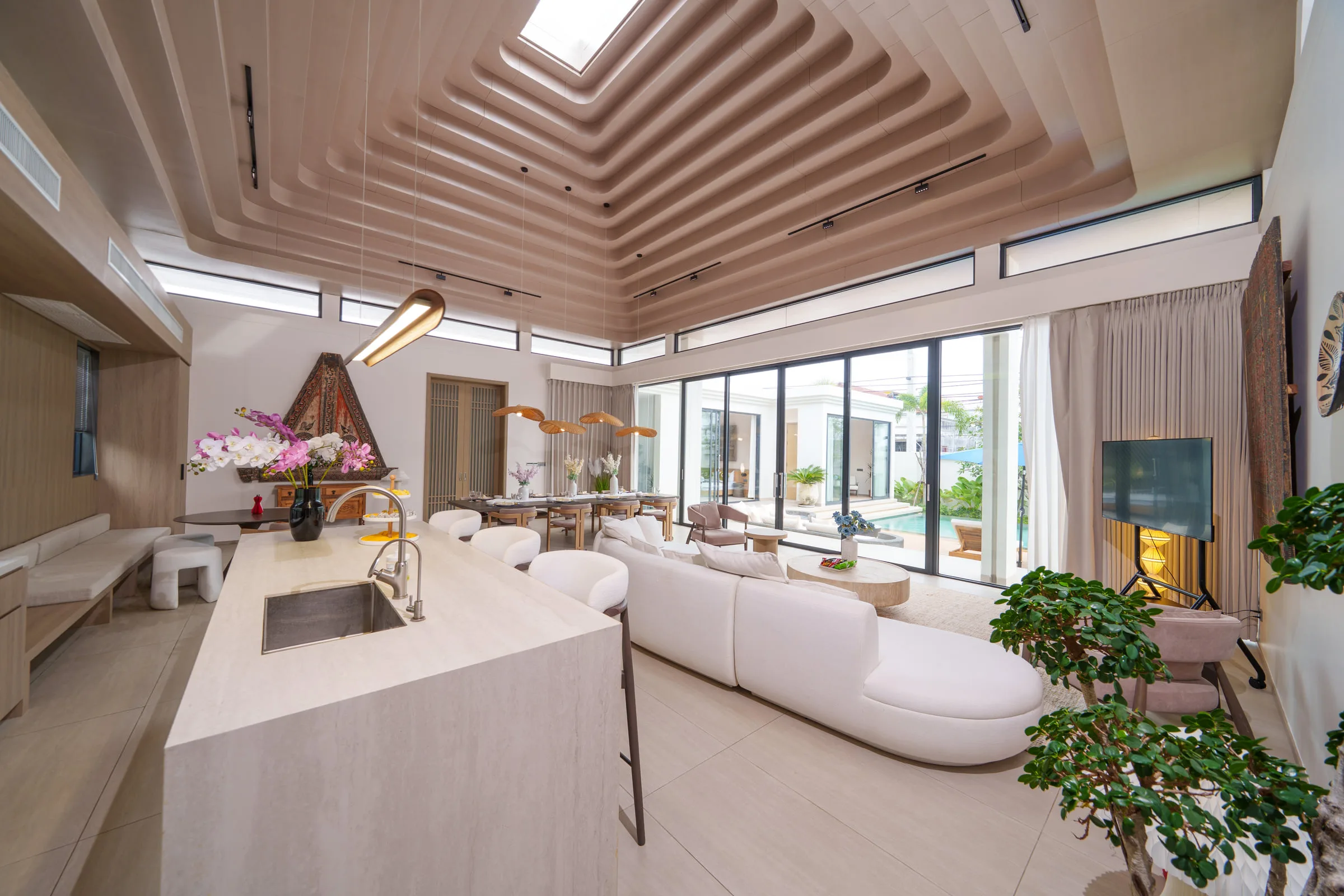 Kitchen island with three bar stools, sink and a window over the counter