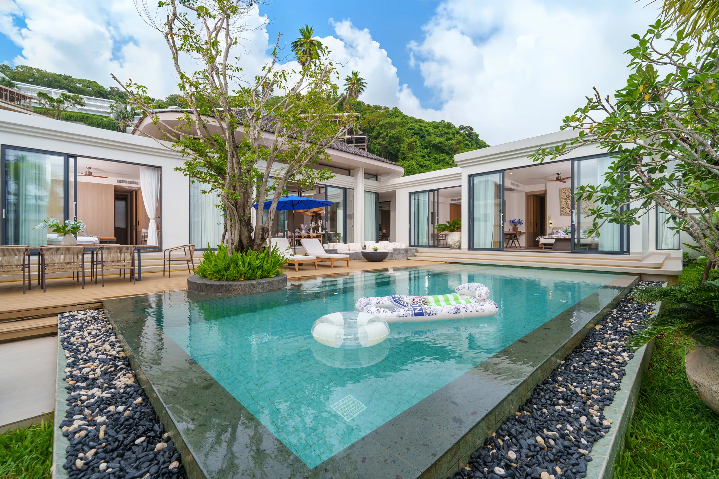 Swimming pool in the courtyard, framed by the two wings of the house and a mature tree