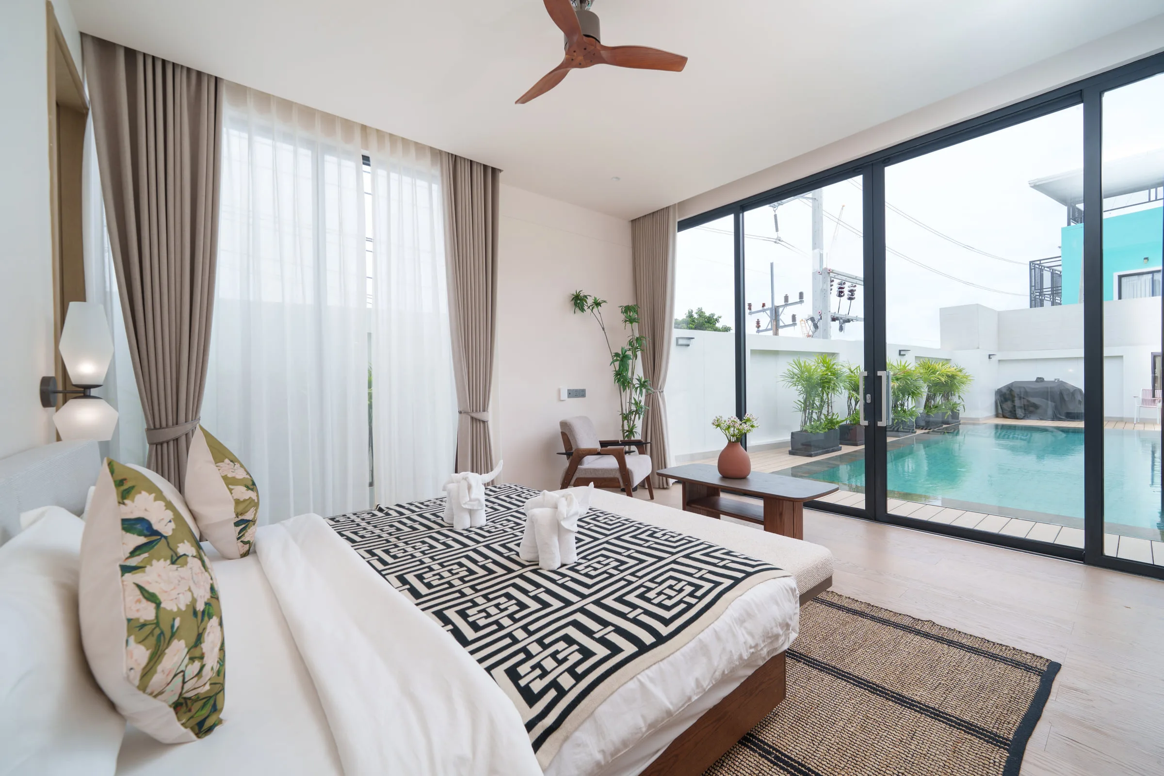 Bedroom with a double bed and sliding doors framing the pool