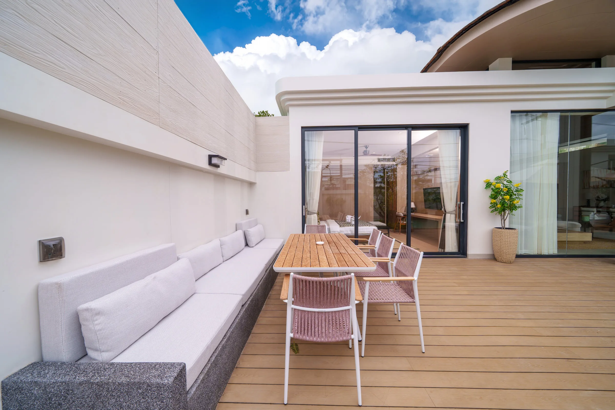 Terrace with a built-in bench, cushions and a timber dining table for six
