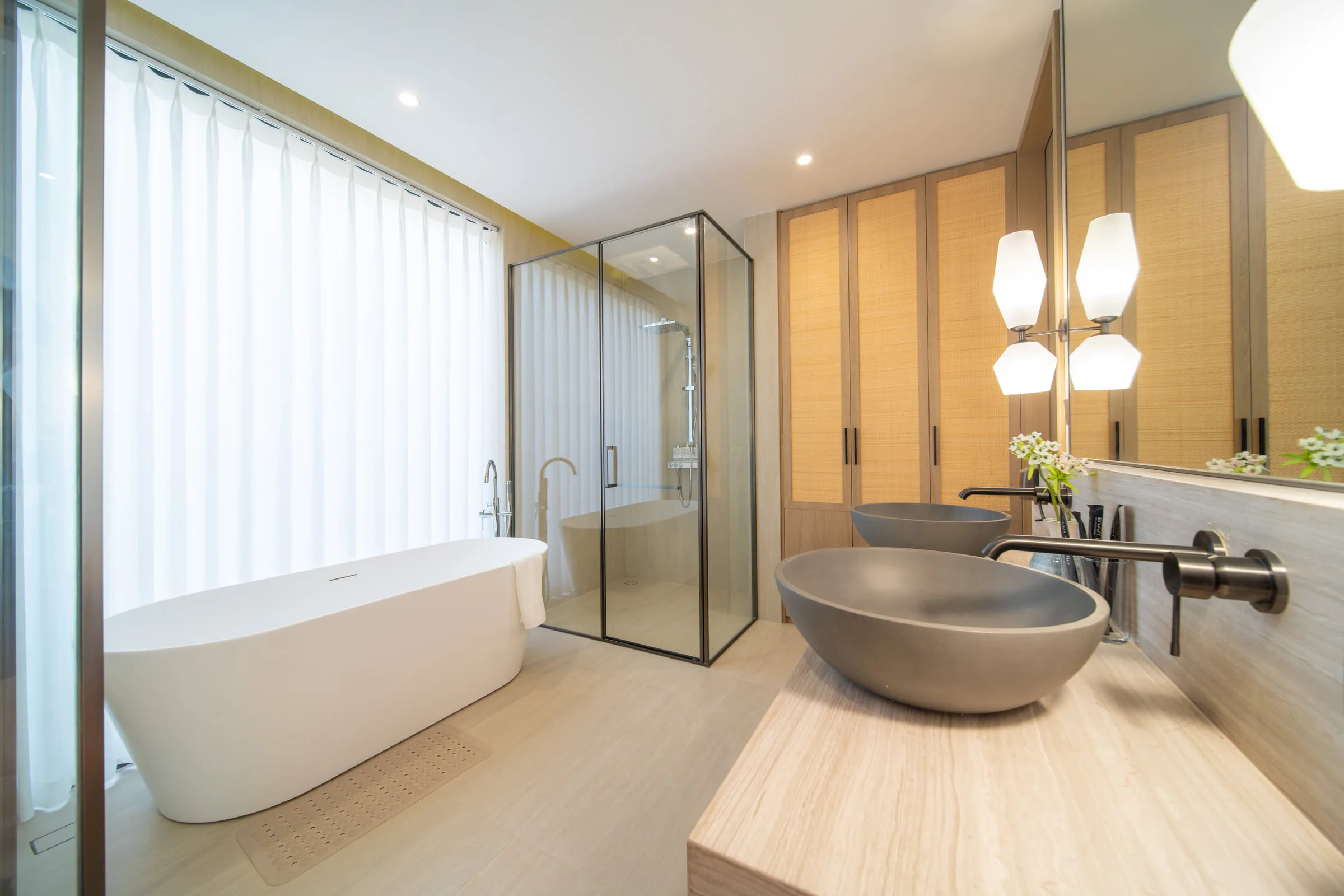 Bathroom with a freestanding bathtub, a stone basin and a glazed shower