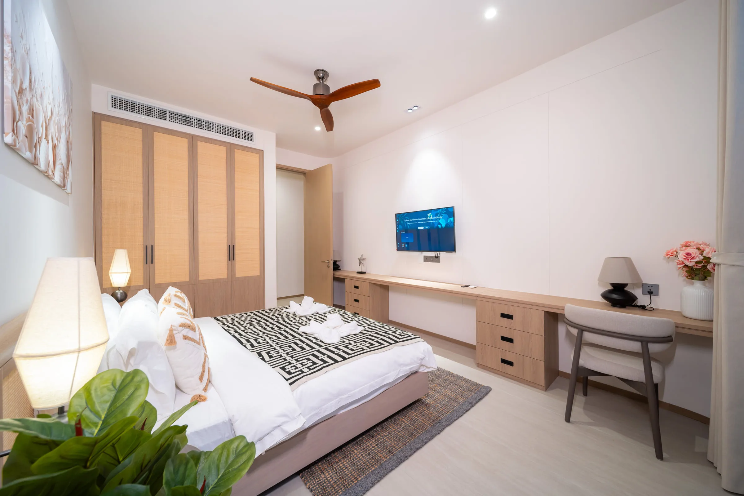 Bedroom with built-in wardrobes, a wall-mounted television and a desk